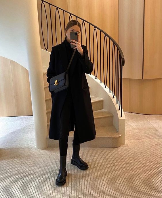 a simple total black look with a turtleneck, skinnies, platform boots, a midi coat and a comfy bag