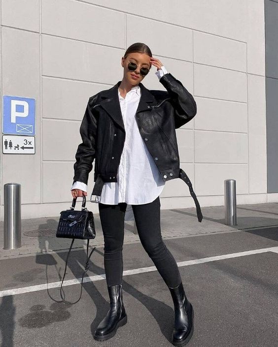 a total black outfit with an oversized leather jacket, skinnies, black boots, a mini bag is refreshed with an oversized white shirt