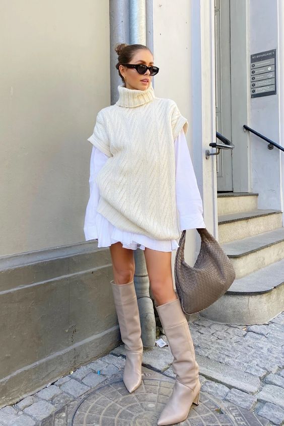a white mini shirtdress, a creamy sweater over it, grey knee boots, a grey woven bag for a super trendy outfit