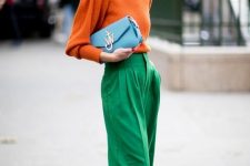an orange turtleneck, emerald trousers, emerald shoes and a pale blue clutch for a work look