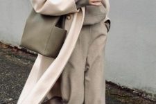 an oversized grey hoodie tucked into matching rey trousers, white trainers, a white coat and a grey tote to wear right now