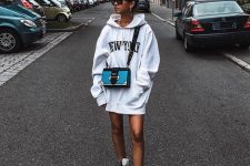 an oversized white hoodie as a mini dress, white combat boots, a blue and black crossbody bag – nothing else is needed