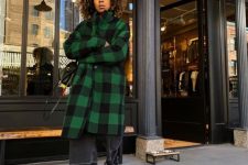 black straight jeans, black combat boots, a green and black plaid midi coat and a black bag for a comfy fall look