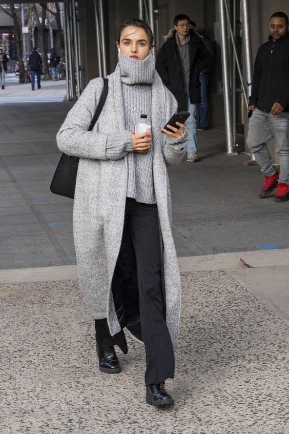 a minimalist work or everyday look with a grey chunky sweater, black thin stripe trousers, black boots, a grey long cardigan and a black bag