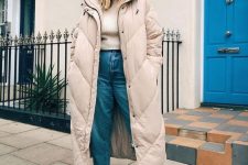 02 a pretty winter look with a neutral top, light blue jeans, white sneakers, a tan midi puffer coat and a white beanie