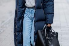 03 a refined winter look with a grey jumper, light blue jeans, dark green booties, a navy puffer coat and a black tote