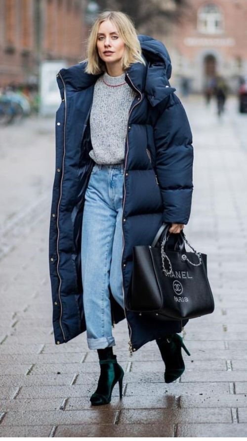 a refined winter look with a grey jumper, light blue jeans, dark green booties, a navy puffer coat and a black tote