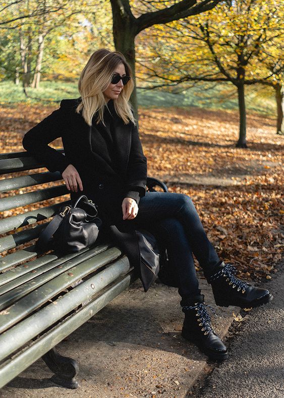 a black jumper, navy keans, black hiking boots, a black coat and a bag for a fall to winter look