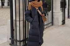 04 a winter outfit in and rust, with lacquer Chelsea boots, a black puffer coat, a rust scarf and a bag, a black beanie
