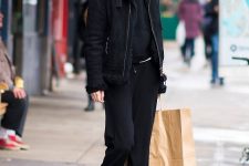 09 Gigi Hadid wearing a total black look with sweatpants, a hoodie, a shearling coat and hiking boots