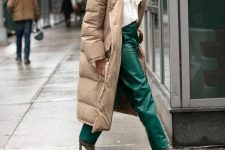 09 a refined winter look with a white blouse with a bow, emerald leather rousers, grey suede boots, a tan puffer coat