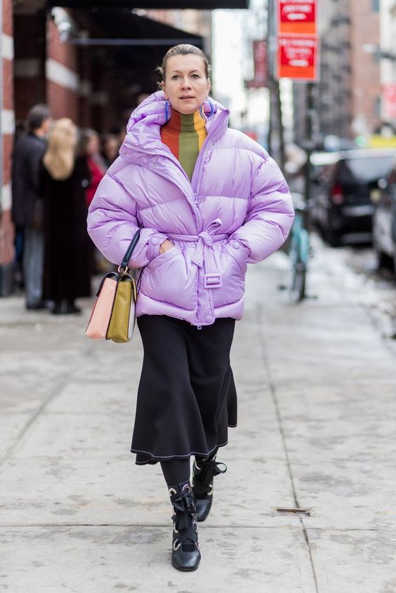 a refined winter look with a color block turtleneck, a black skirt and lace up boots, a lilac belted puffer jacket