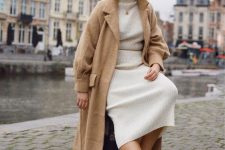 20 a lovely winter look with a creamy midi sweater dress, a tan fuzzy coat, neutral trainers and a coin necklace