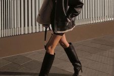 23 a black mini sweater dress,  a black shearling jacket, black knee boots and a black bag