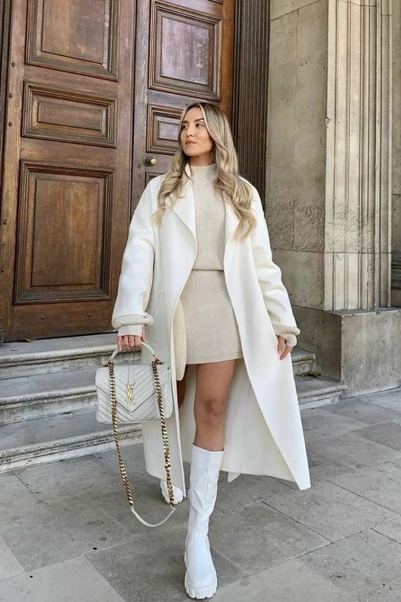a neutral winter outfit with a tan knit suit   a turtleneck and a mini skirt, a creamy coat and a bag, white boots