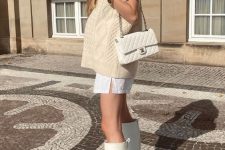 32 an all-neutral outfit with a white t-shirt mini dress, a creamy patterned chunky vest, a creamy bag and white kneed platform boots