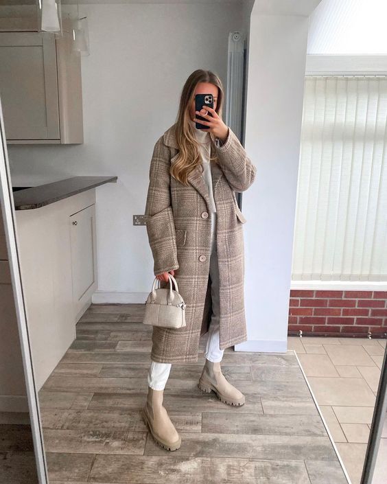 a chic winter outfit with a white turtleneck and jeans, a tan plaid midi coat, tan Chelsea boots and a creamy bag