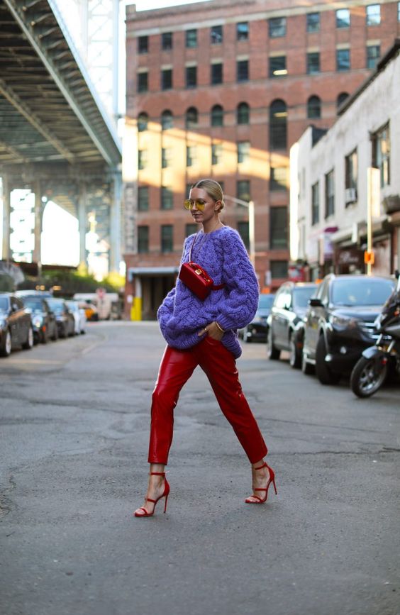 a bright look with a purple chunky patterned sweater, red leather trousers, red strap shoes and a bag