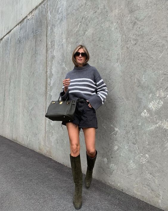 a sexy and trendy outfit with a grey oversized striped sweater, a black denim mini, green knee boots and a black tote