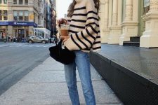 51 a simple and classy outfit with an oversized black and white striped sweater, light blue jeans, black heels and a black velvet bag