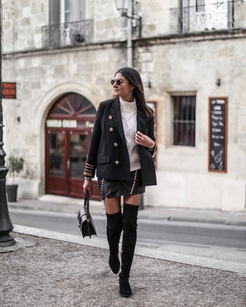 With black leather asymmetrical mini skirt, sunglasses, black embellished bag and black suede over the knee boots