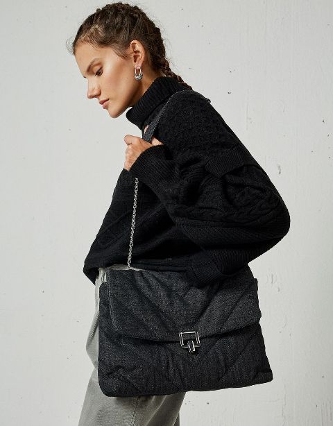 With black loose turtleneck sweater and gray high-waisted trousers