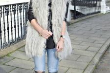 With black shirt, distressed jeans, faux fur vest and bag