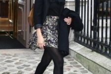 With black shirt, printed mini skirt, black blazer, brown bag and black scarf