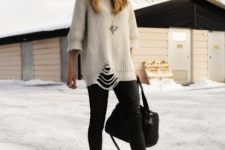 With black skinny pants, beige distressed sweater and black bag