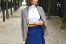 With blue high-waisted maxi skirt and golden necklace