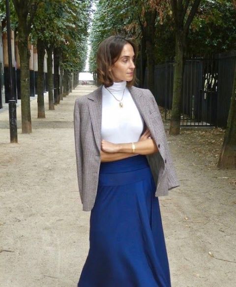 With blue high-waisted maxi skirt and golden necklace