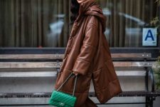 With brown leather cropped pants, black sock boots and brown oversized puffer coat