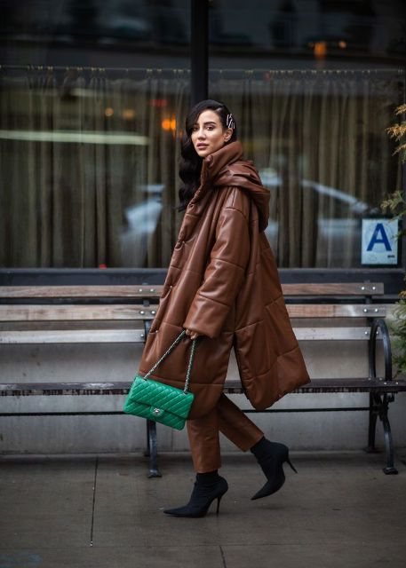 With brown leather cropped pants, black sock boots and brown oversized puffer coat