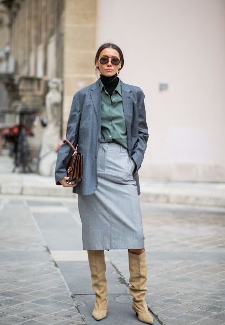 With button down shirt, brown bag, gray midi skirt and beige low heeled high boots