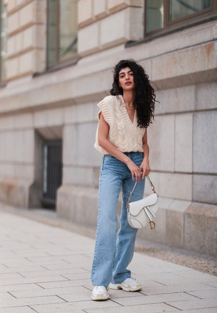 With light blue flare jeans, white bag and white sneakers