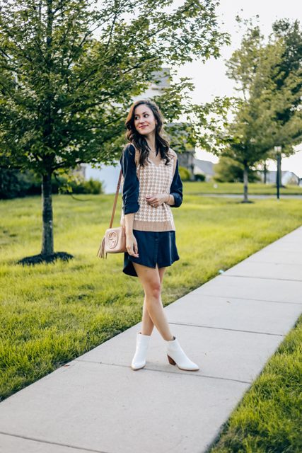 With navy blue shirtdress, brown tassel bag and white low heeled ankle boots