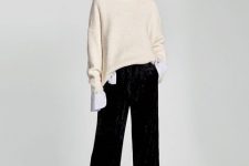 With white long sleeved shirt, beige turtleneck sweater and black sock boots