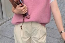 With white t-shirt, beige trousers and brown leather clutch