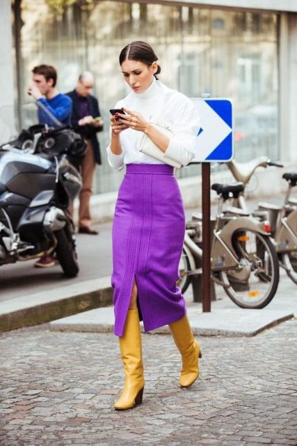 With white turtleneck, white shirt, white clutch and lilac midi skirt