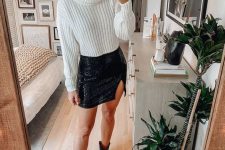14 a classy winter look with a white cropped chunky jumper, a black sequin mini and black cowboy boots