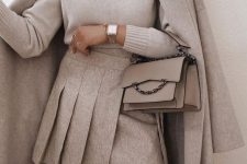 20 a neutral outfit with a white turtleneck, a wide pleated asymmetrical mini, a grey coat, a grey mini bag