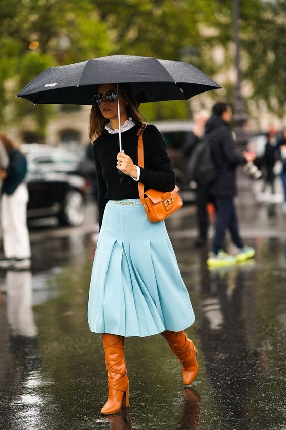 a catchy look with a black top and a white shirt underneath, a blue wide pleated midi, amber boots and an amber bag