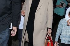 J.Lo wearing a black turtleneck, black leggings, white sneakers, a tan midi coat for a super comfortable look