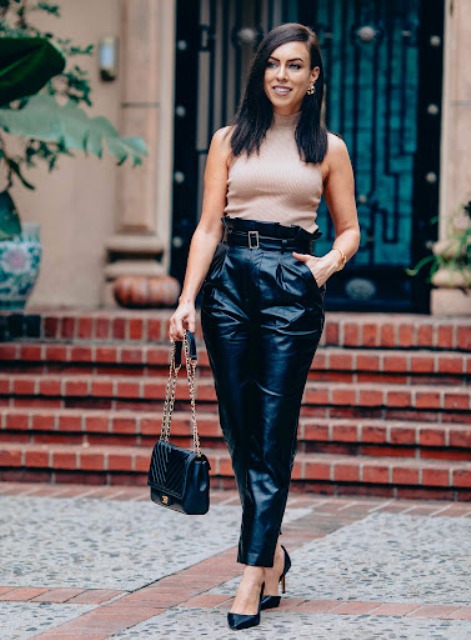 With beige sleeveless turtleneck, black leather chain strap bag and black leather pumps