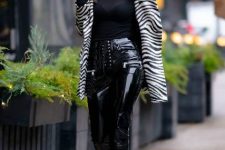 With black shirt, zebra printed long jacket and black mid calf boots