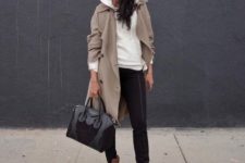 With black skinny pants, sunglasses, black patent leather bag and brown lace up boots