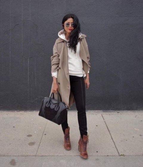 With black skinny pants, sunglasses, black patent leather bag and brown lace up boots