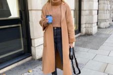 With brown turtleneck sweater, cropped high-waisted jeans, black leather bag and beige leather ankle boots