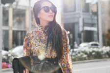 With colorful floral printed long sleeved blouse, oversized sunglasses and black leather clutch