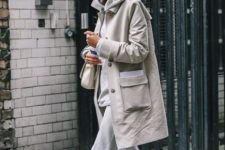 With light gray cropped pants, beige bag and white sneakers